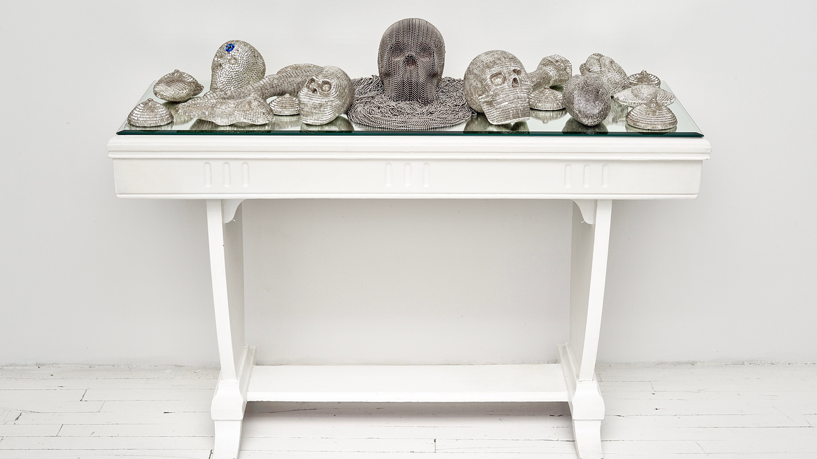 Esperanza Cortés; SECOND SIGHT; 2008 – 2018; 20 clay sculptures, glass beads, mirror, table. Second Sight honors the Curandera (healer) in Latinx culture as a whole, as well as the personal connection to my grandmothers who were both curanderas in Colombia. These individuals dedicated their lives to maintaining the physical and spiritual well being and equilibrium of their families and communities. Each individual piece represents the instruments and fruits of their Labors.