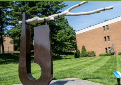 outdoor sculpture of wood and metal with branch