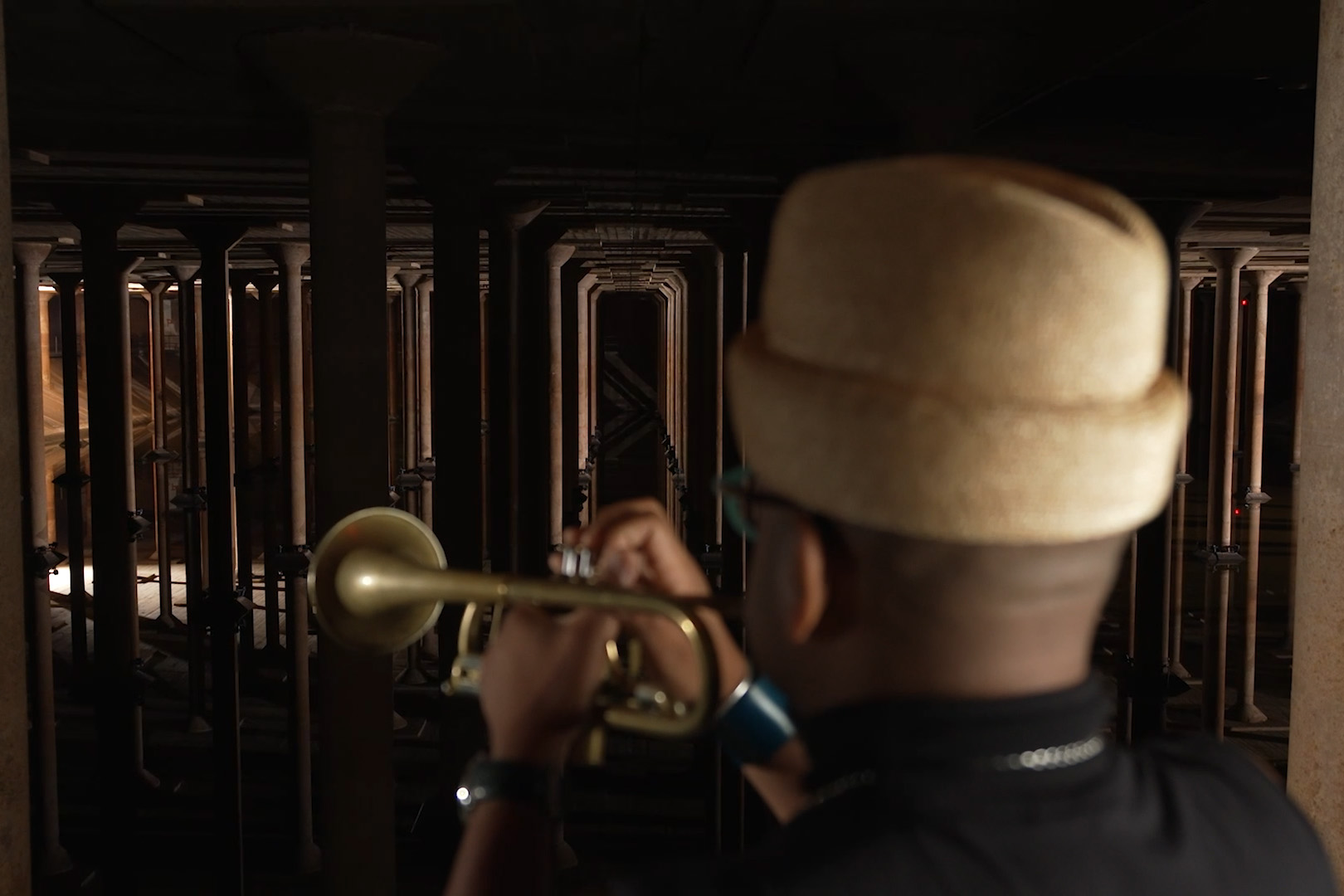 Back of man playing trumpet in cisterns