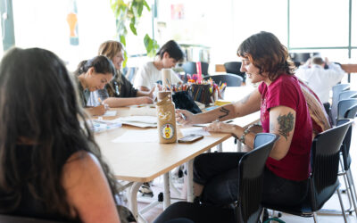 group of people sitting around table making art