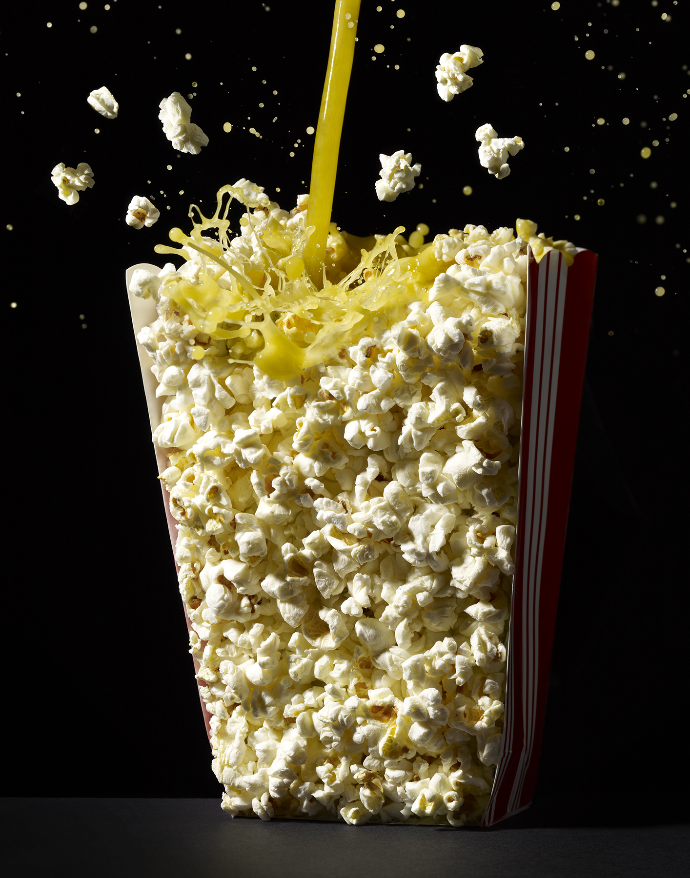 side view of popcorn with butter splashing down