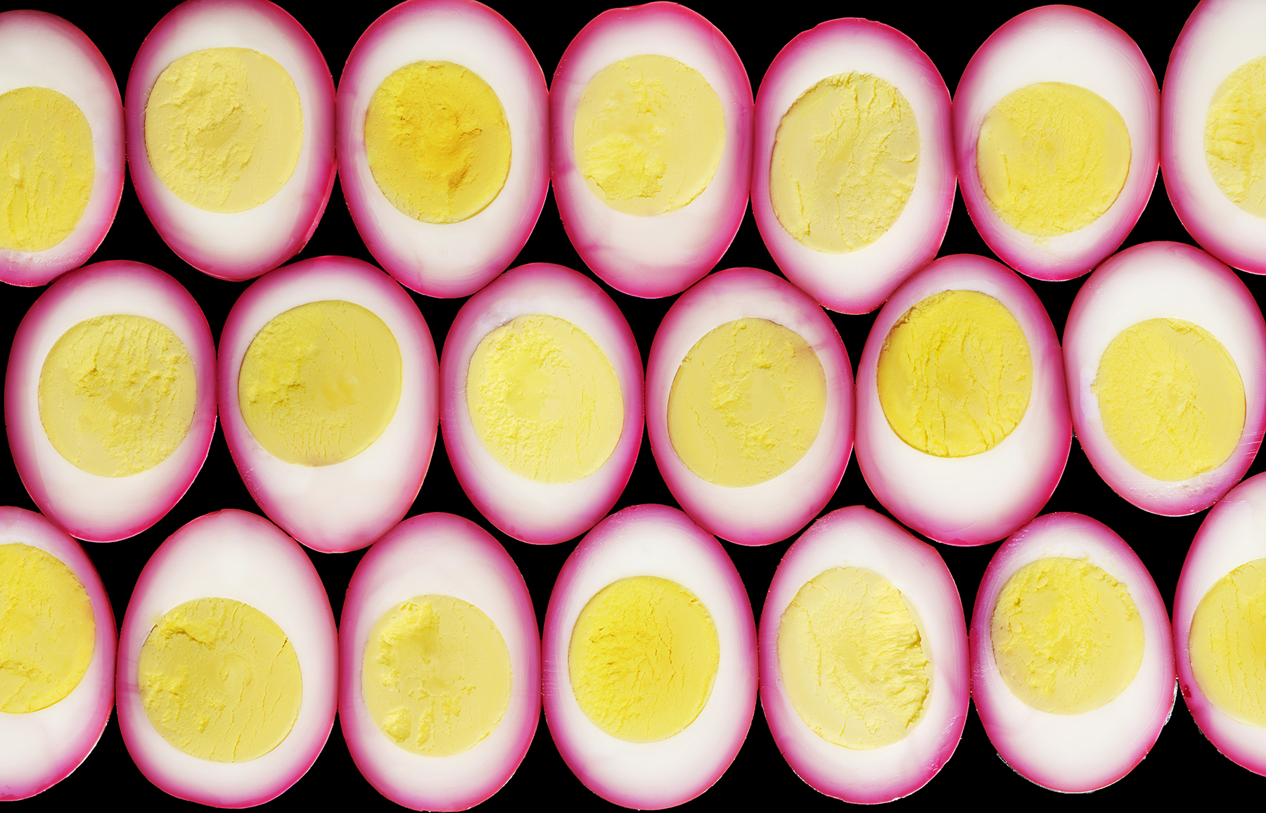 top down view of cut deviled eggs with pink outsides and yellow yolks