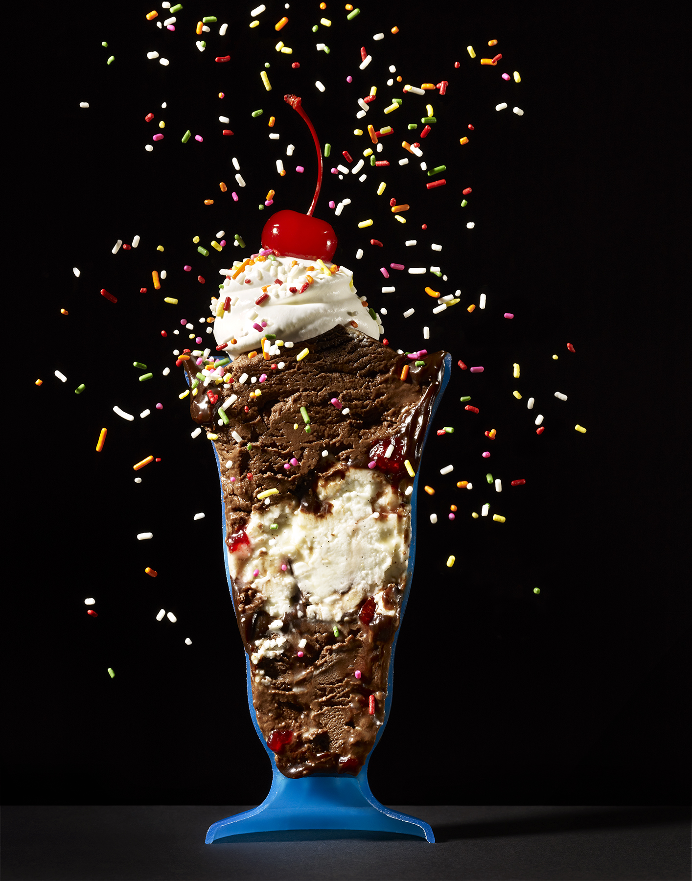 side view of ice cream sundae in blue cup with sprinkles